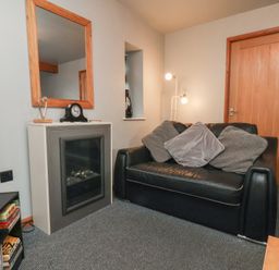 A living room with a sofa and a mirror at Fortunatus in Whitby