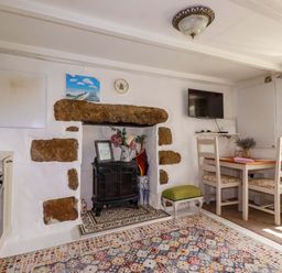 A kitchen with a table and chairs at Longview Cottage in Penwithick neat St Austell
