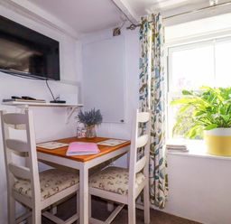 A dining area with a table and chairs at Longview Cottage Penwithick near St Austell