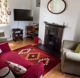 A living room with two armchairs a sofa a rug and a fireplace at Anvil Lodge in Goulceby near Louth