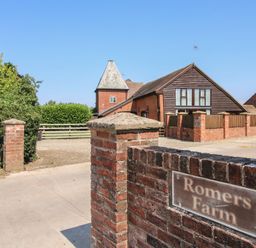 An outdoor view of a farm entrance with a brick wall and a house at Romers Farm Bockleton near Tenbury Wells