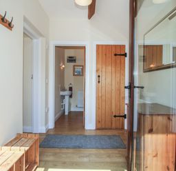 A hallway with a bench and coat hooks at The Wainhouse in Bockleton near Tenbury Wells