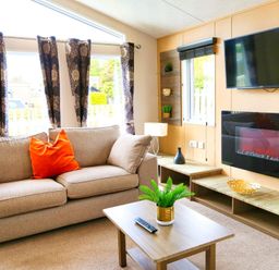 A living room with a sofa and television at Cheri in Southerness