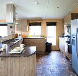 A kitchen with appliances and dining set at Cheri in Southerness