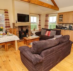 A living room with a sofa and dining area at West Gate in Embleton