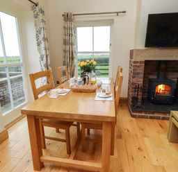 A dining room with a table and chairs at Bank Top Cottage in Embleton