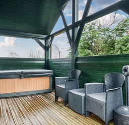 An outdoor area with a hot tub and chairs at Ash Lodge in Pennington near Ulverston