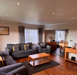 A living room with sofas and a coffee table at Rhos Helyg near Penysarn Amlwch