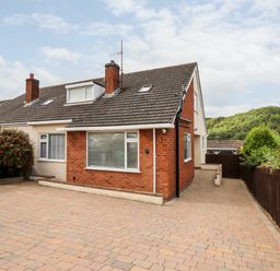 A semi detached house with a paved driveway and a wooden fence at 4 Bodnant Road in Rhos-On-Sea