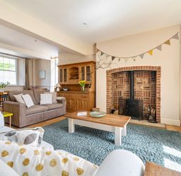 A living room with a fireplace and seating at East Wing in Crewkerne