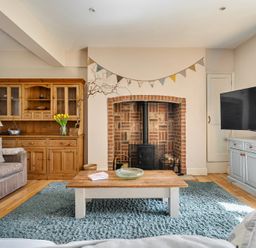 A living room with a fireplace and television at East Wing in Crewkerne