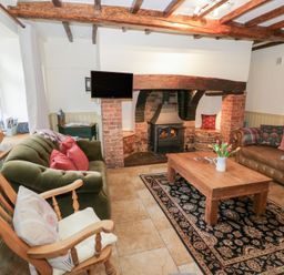 A living room with a fireplace and seating at Town Mill in Bewdley