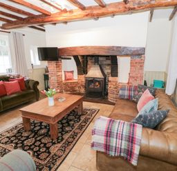 A living room with a fireplace and seating area at Town Mill in Bewdley