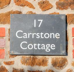 A house number sign reading 17 Carrstone Cottage on a stone and brick wall at Carrstone Cottage Heacham