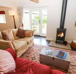 A living room with a wood stove and seating area at Gallow Law Cottage Bellingham