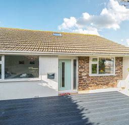 An exterior view of a house with a deck at Sunset View in Porth