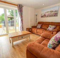 A living room with a sofa and coffee table at Mallows Byre in Yetminster