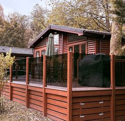 A deck area with a grill and seating at Coniston Number 9 in White Cross Bay