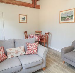 A living room with a sofa and dining area at The Cider Press, Motcombe