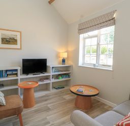 A living room with a sofa and television at The Apple Shed, Motcombe