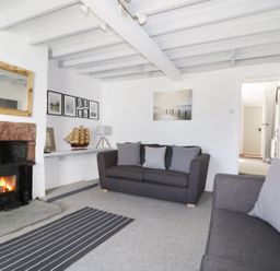 A living room with two gray sofas and a fireplace at Marsh Villa in Silloth