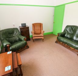 A living room with seating and a laptop at White Thorns in Haverfordwest
