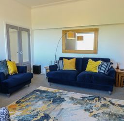A living room with a sofa and armchair at Little Orme View in Llandudno