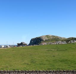 A landscape view with a mountain and houses at Little Orme View in Llandudno