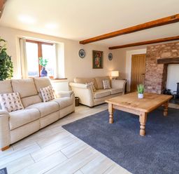 A living room with sofas and a wooden table at The Linhay Washford near Watchet