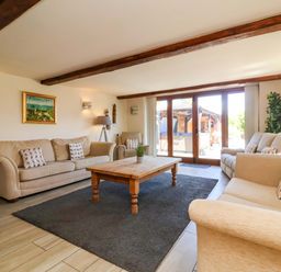 A living room with sofas and a wooden table at The Linhay Washford near Watchet