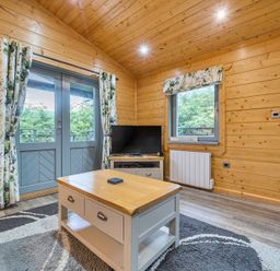A living room with a television and a coffee table at Elm Lodge in Ulverston