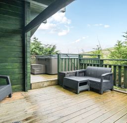 A balcony with a hot tub and seating area at Elm Lodge in Ulverston