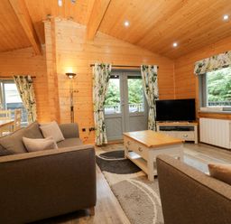 A living room with a sofa and a television at Elm Lodge in Ulverston