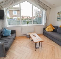 A living room with a sofa and coffee table at Sunrise Cottage in Beadnell
