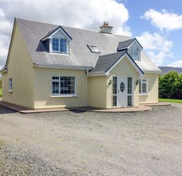 A detached house with two dormer windows and a gravel driveway at The Slate House in Cahersiveen County Kerry
