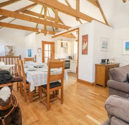 A dining area with a table and chairs next to a kitchen and living room at Mill in Nancegollan nr Porthleven