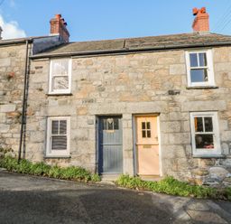 A stone cottage with two front doors and four windows on a sloped street at Pippin in Lelant