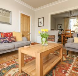 A living room with sofas pillows table and a vase with flowers at Haven in Porthleven