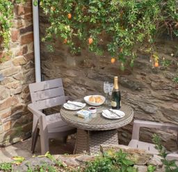 A table with chairs and champagne at Mithian Cottage St Agnes