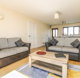 A living room with two sofas a coffee table and a rug at Seashells in Marazion
