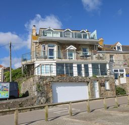 A multi-story stone house with glass balconies and a garage door at Mount View in Marazion