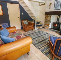 A living room with a sofa and armchair at May Cottage in Pentewan
