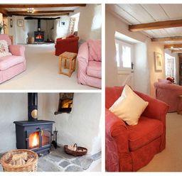 A living room with armchairs a wood burning stove and wooden beams at Rose Cottage in Manaccan