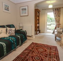 A living room with a sofa and television at Banneth in Helford