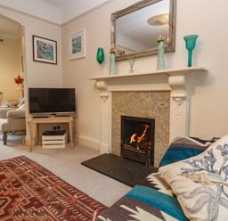 A living room with a television and fireplace at Banneth in Helford