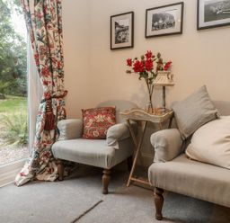 A snug with two armchairs and a small table at Banneth in Helford