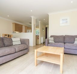 A living room with two sofas a wooden coffee table and a dining area at Trelease in Falmouth