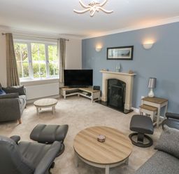 A living room with a television and sofas at Glebe House in Bigbury