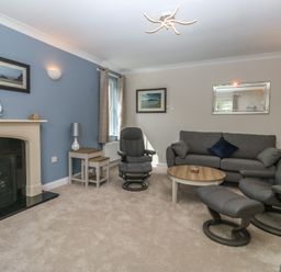 A living room with sofa and armchairs at Glebe House in Bigbury