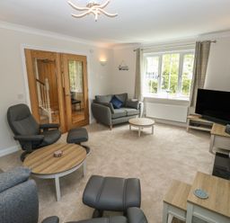 A living room with seating and a television at Glebe House in Bigbury